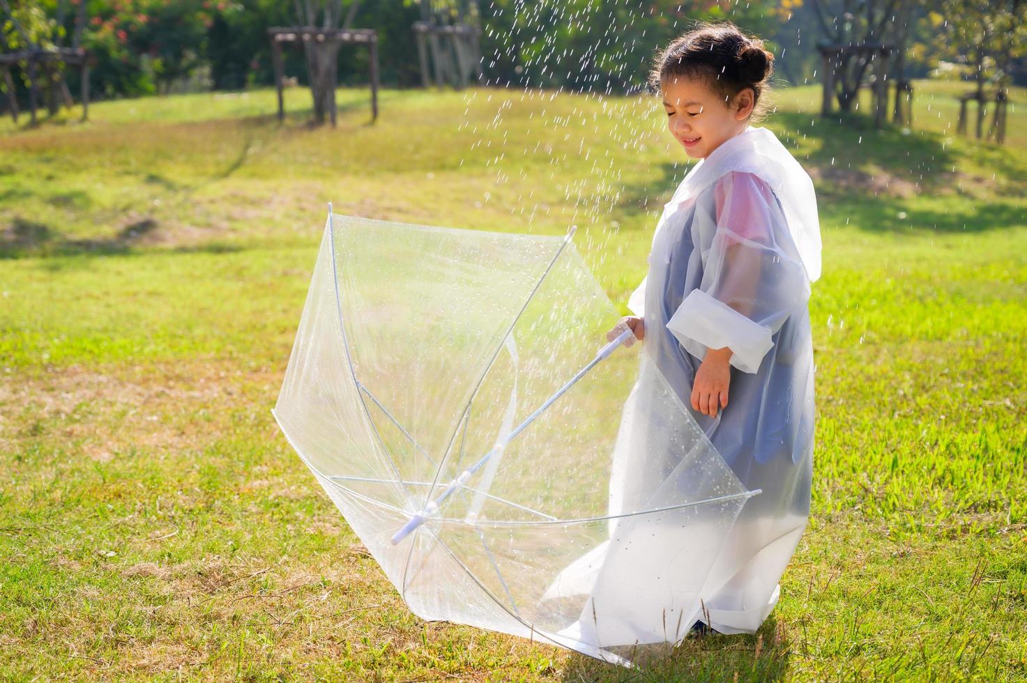 A little girl was happily standing in an umbrella against the rain photo