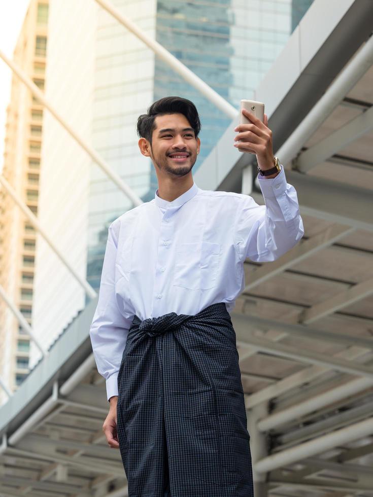 Young Burmese businessman using mobile phone to find a data for his business photo