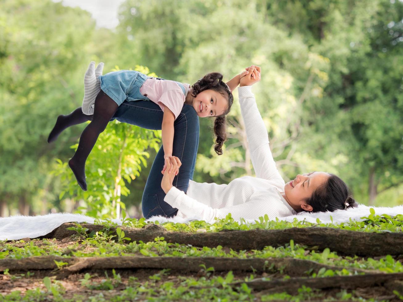 An Asian girl is lying on her mother's legs lying on the floor photo