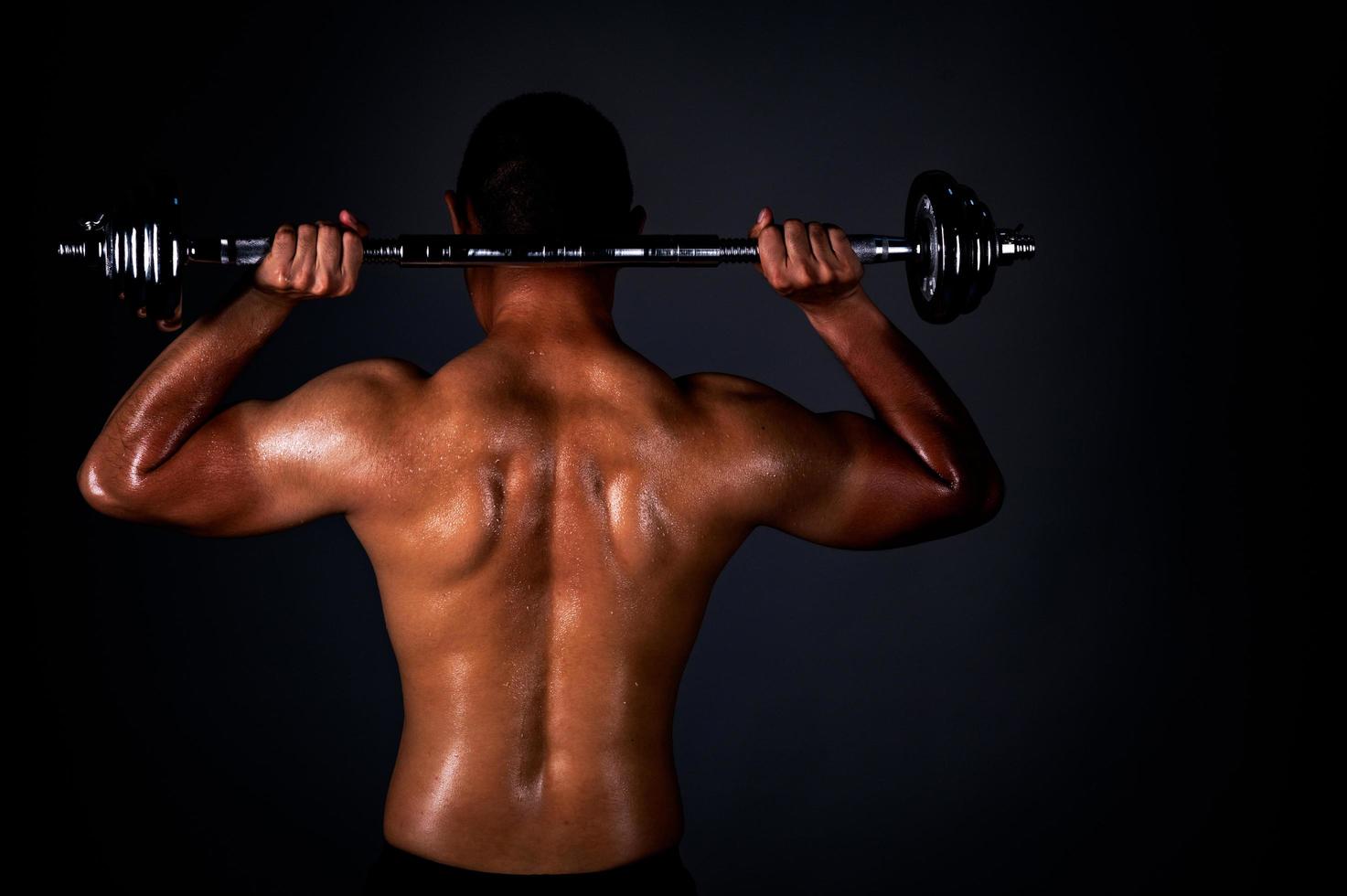 The strong Asian man lifted his dumbbell regularly to keep his muscles strong and beautiful photo