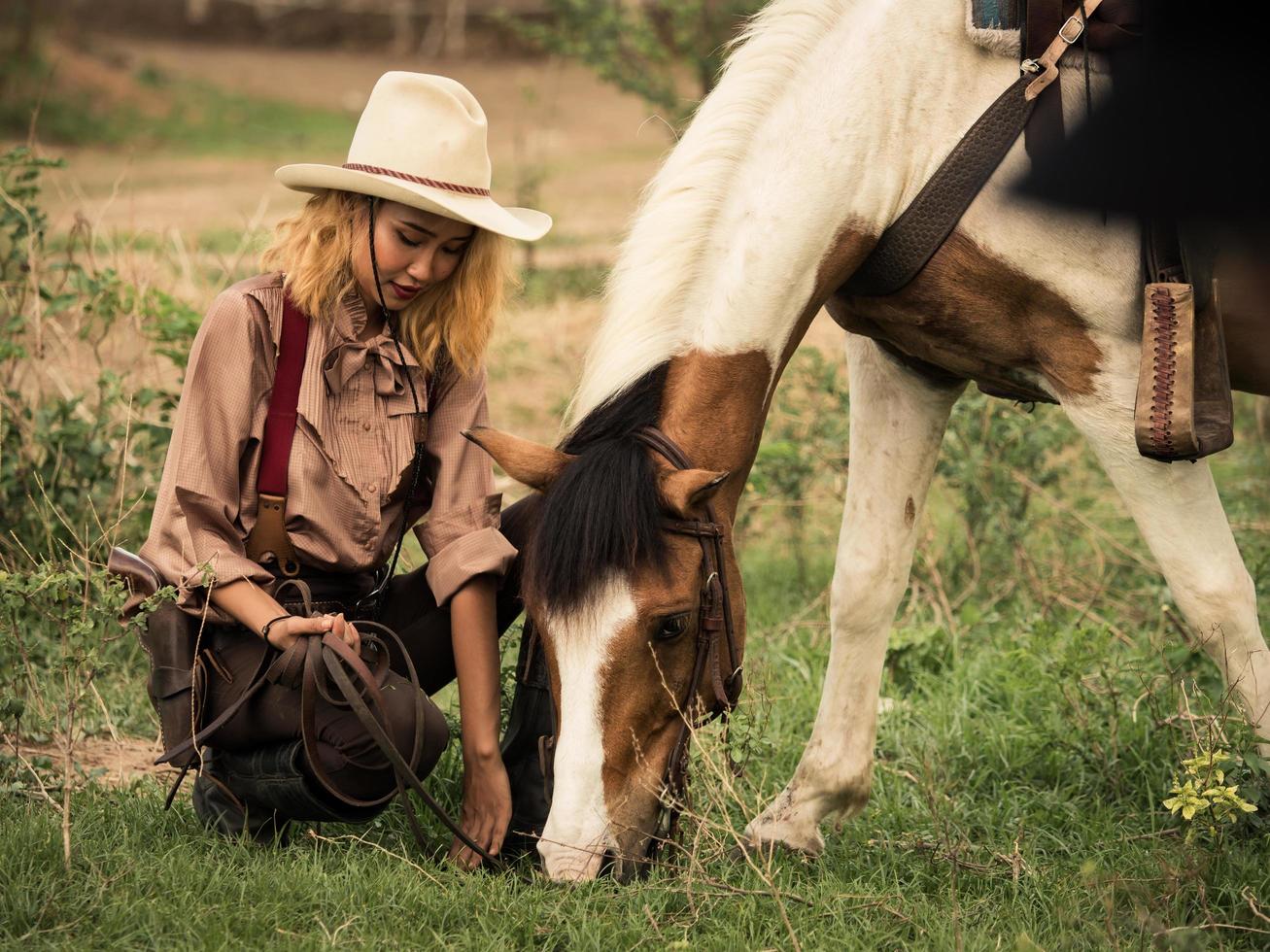 Cowgirl and the horse are deeply bonded to each other in love because of their distressed relationships in a wild outlaw photo