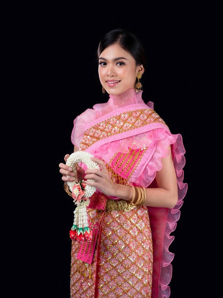 Attractive Thai woman dressed in traditional Thai clothes holds a flower garland made from natural materials photo