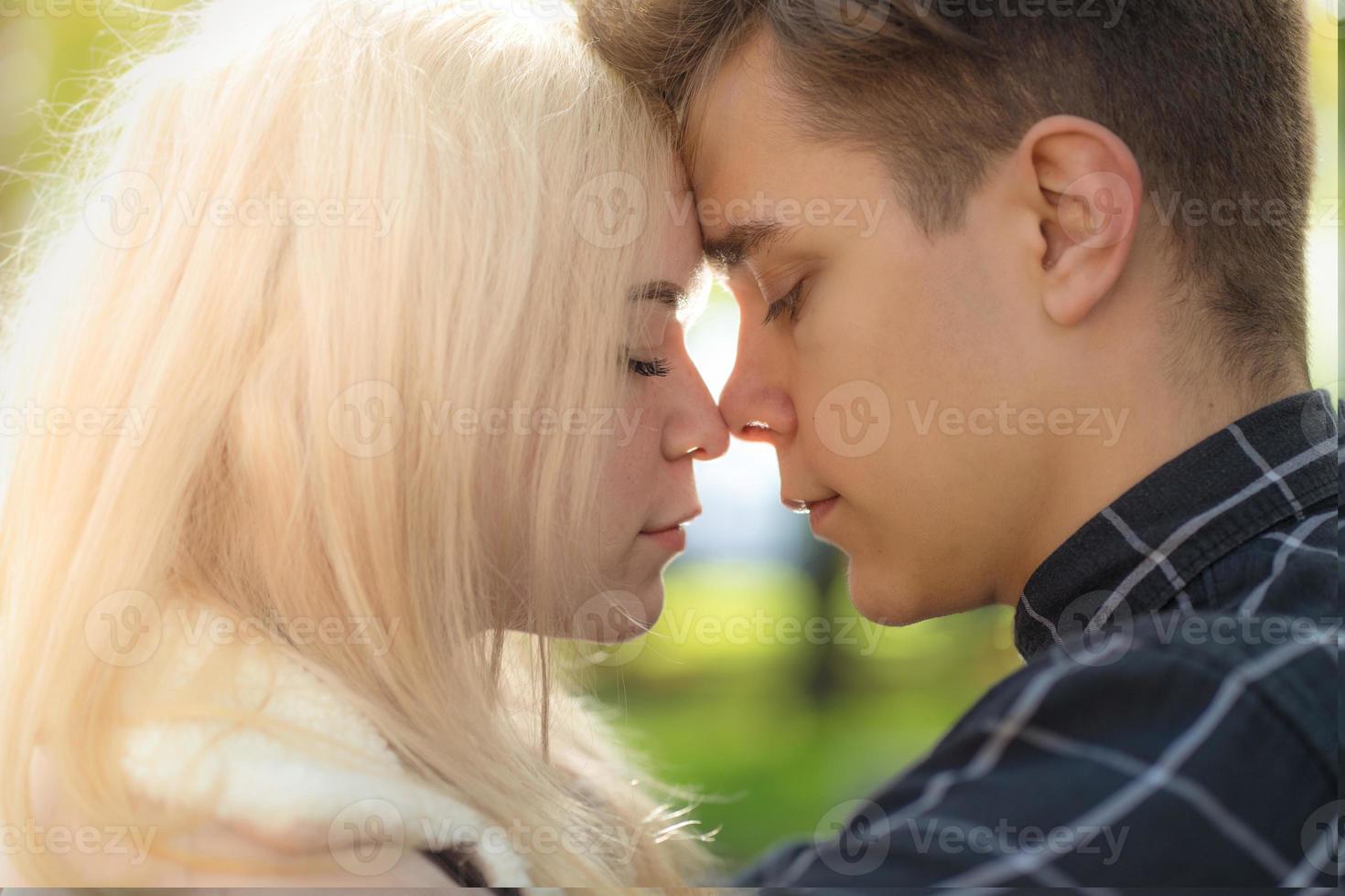 el hombre llama cariñosamente mira a la mujer, el chico y la chica valen la pena cerca, tocando las puntas de las narices. el concepto de primer amor adolescente y primer beso. chico y chica, pareja. intimidad, honestidad, confianza, foto