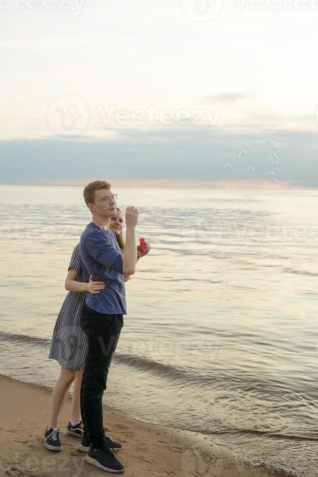 pareja adolescente, soplar, sopa, burbujas, en la playa foto