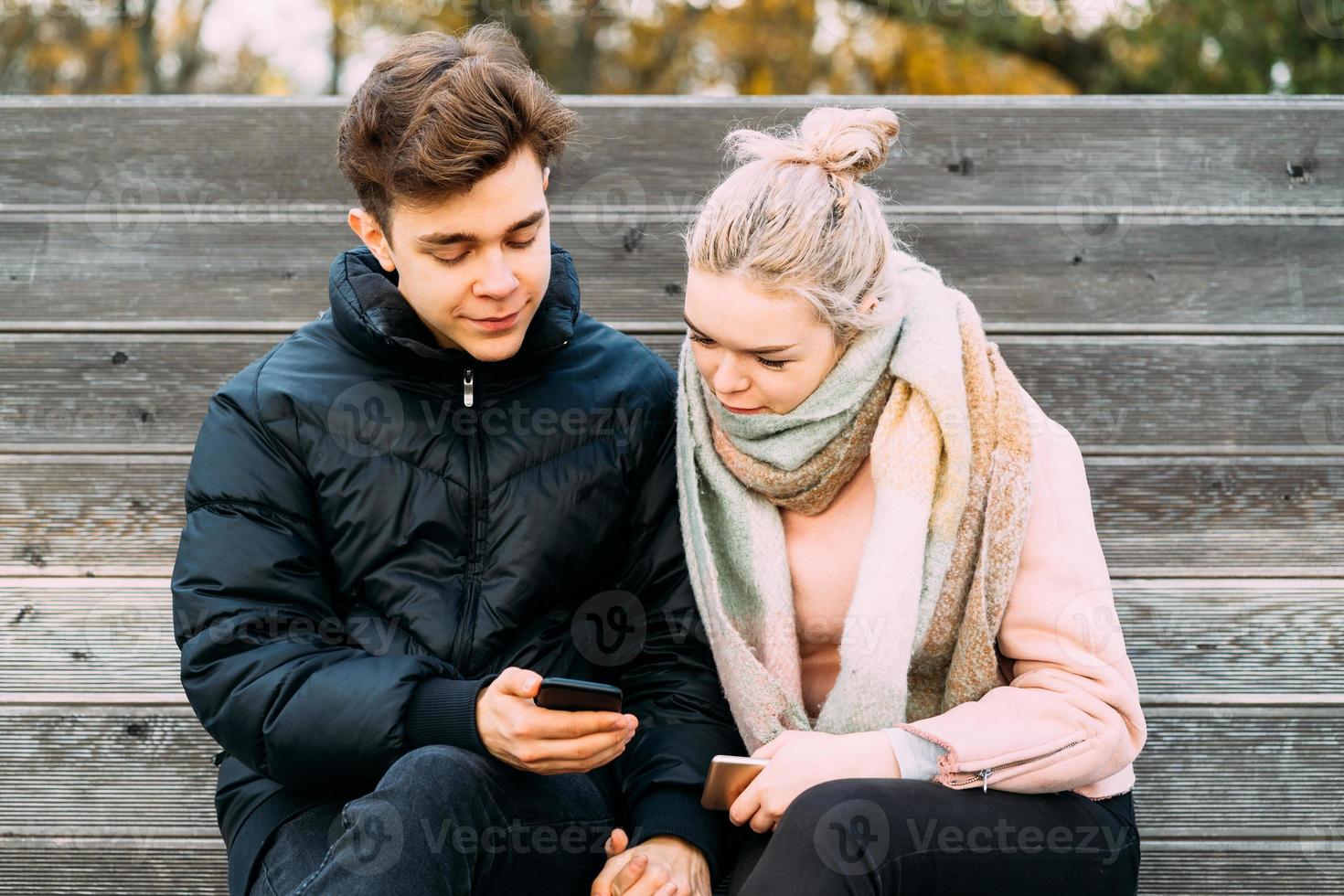 Teenage love concept. Cute brunette guy young blonde girl photo