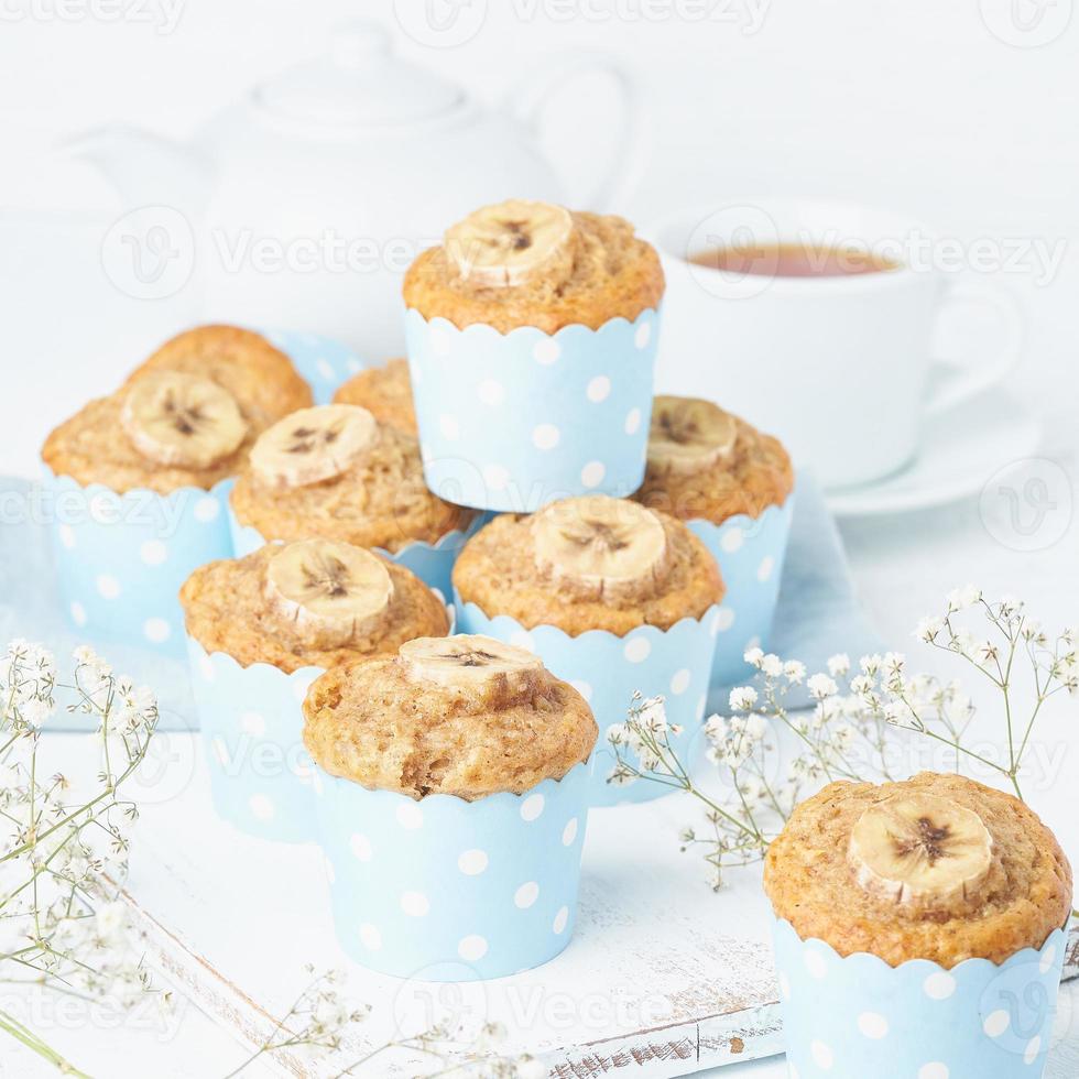 muffin de plátano, pastelitos en papel de cajas de pastel azul, mesa de hormigón blanco, vista lateral foto