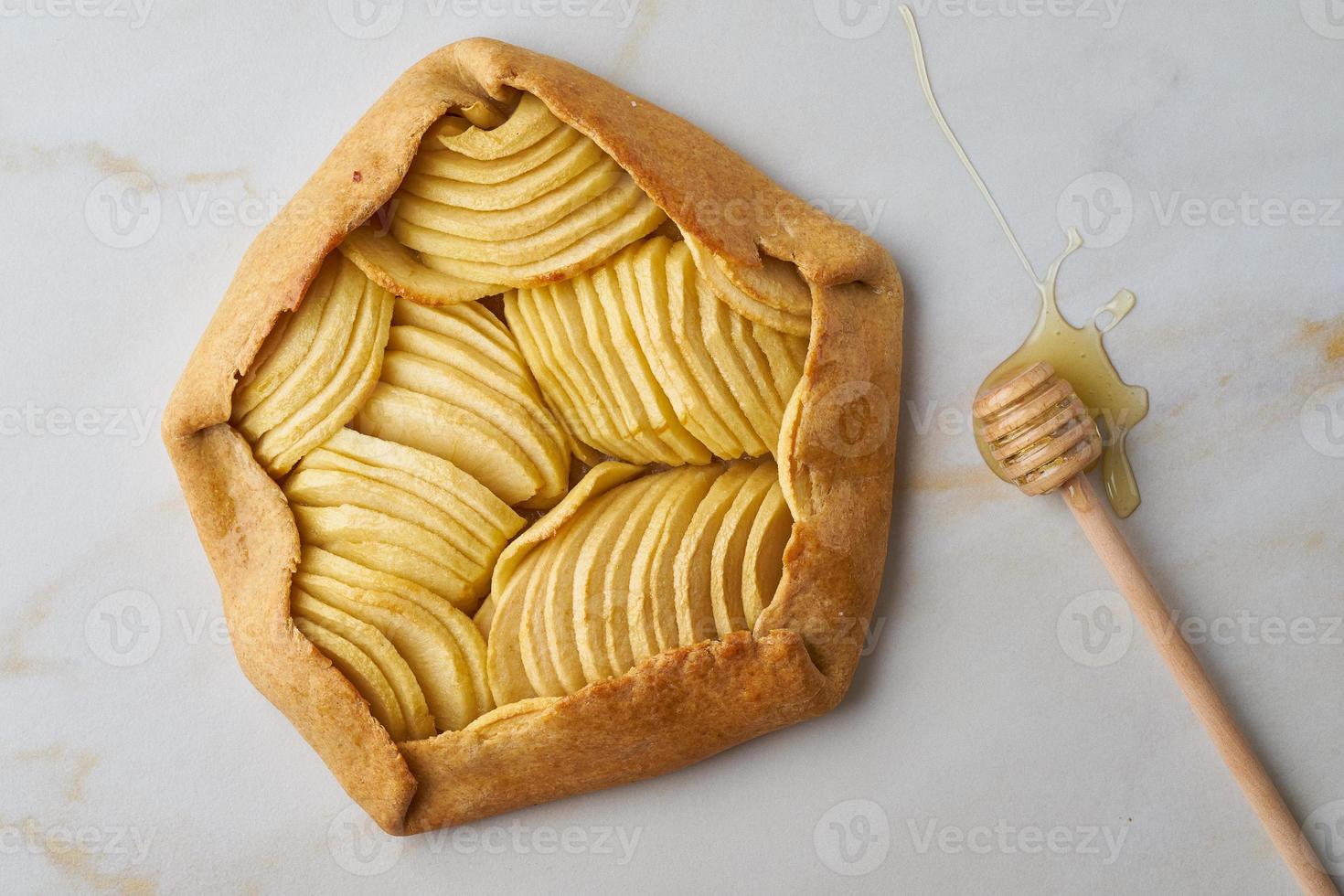 galette de manzana, tarta con frutas y miel, bollería dulce sobre mesa de mármol, vista superior foto