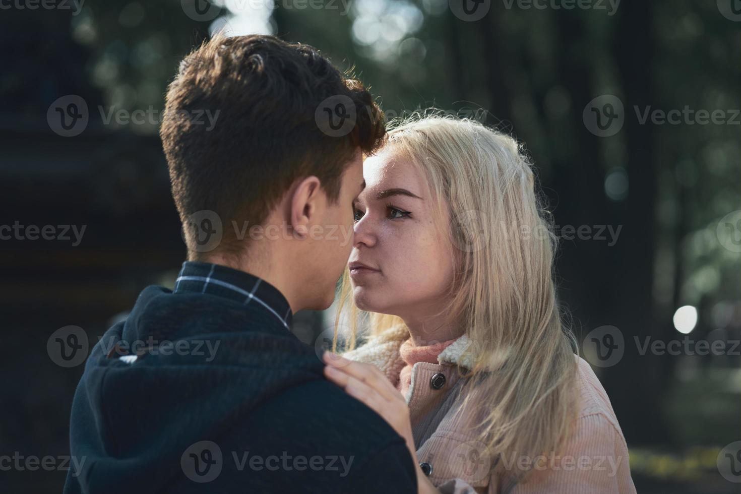 hombre y mujer se miran, pareja joven llena de amor en el parque de otoño. concepto de amor y felicidad adolescente foto