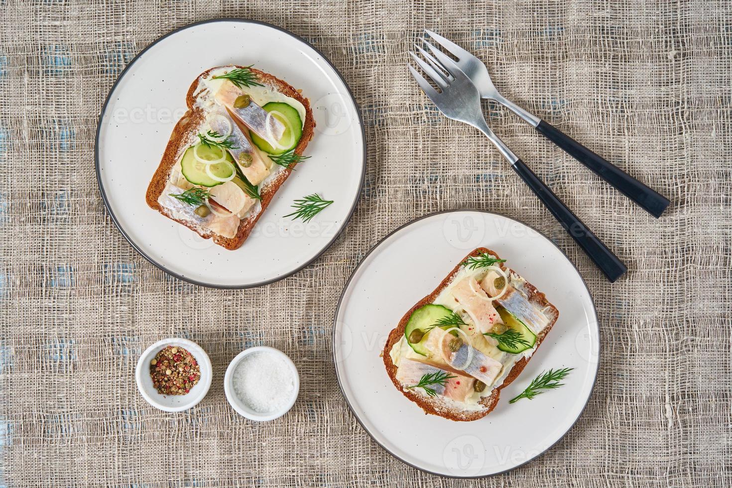 Herring smorrebrod - traditional Danish sandwiches. Two plate with black rye bread photo