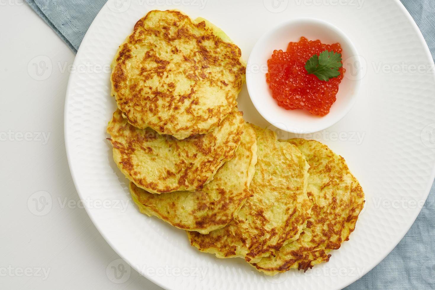 Zucchini pancakes with potato and red caviar, fodmap keto diet top view closeup photo