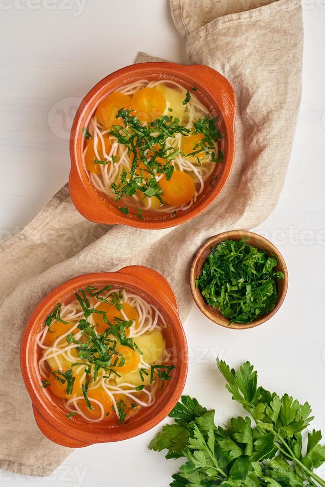 Healthy chicken soup with vegetables and rice noodles, fodmap dash diet, top view photo