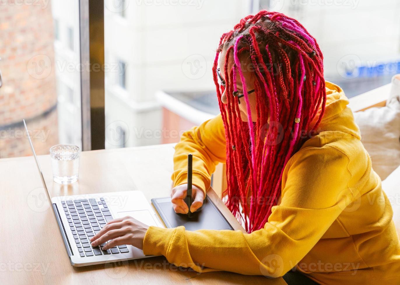 Digital nomad concept. Girl freelancer remotely working on laptop in cafe, coworking. photo