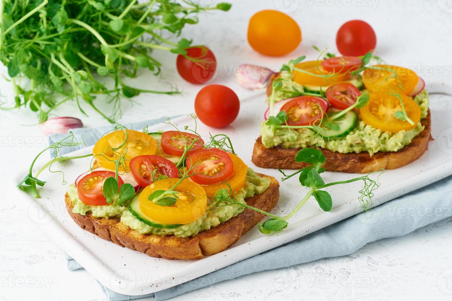 tostadas de aguacate con tomates cherry y hierbas, desayuno, primer plano foto