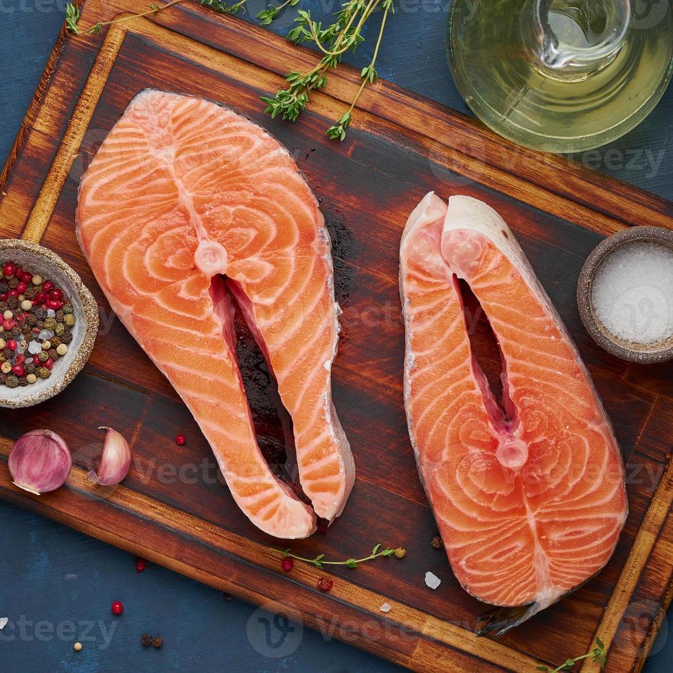 dos filetes de salmón, filete de pescado, grandes porciones en rodajas en una tabla de cortar foto