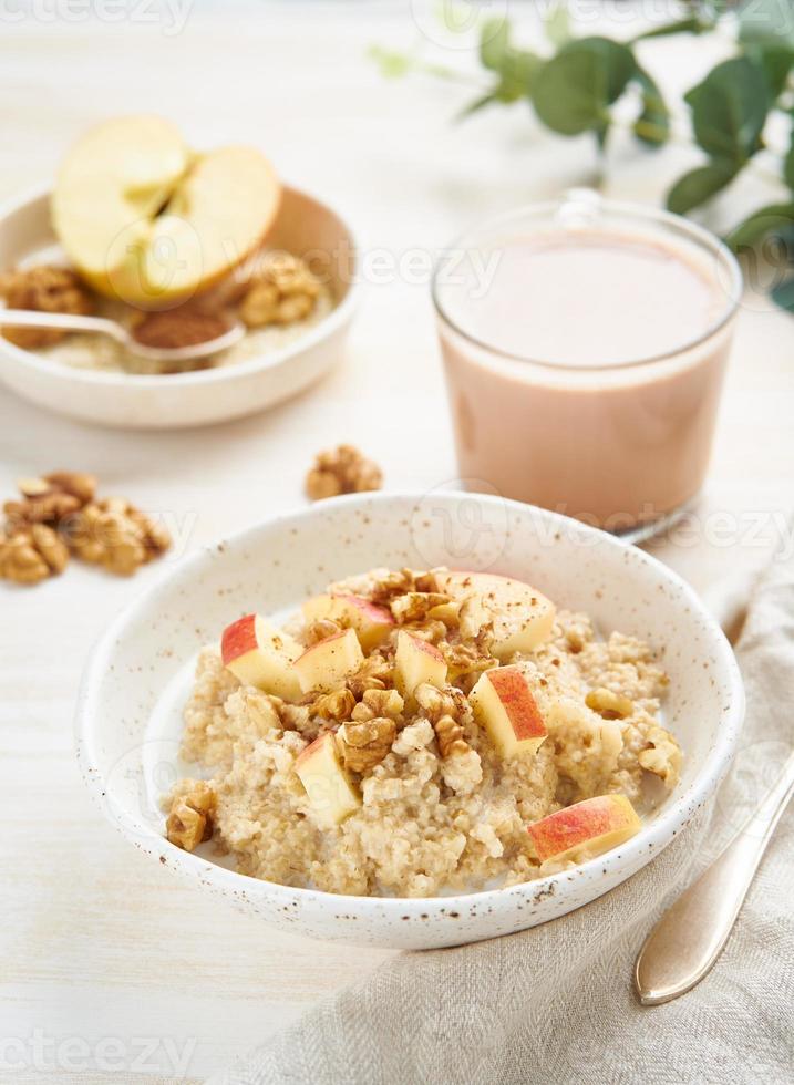 Oatmeal with apple, nuts, honey and cup of chocolate on white photo