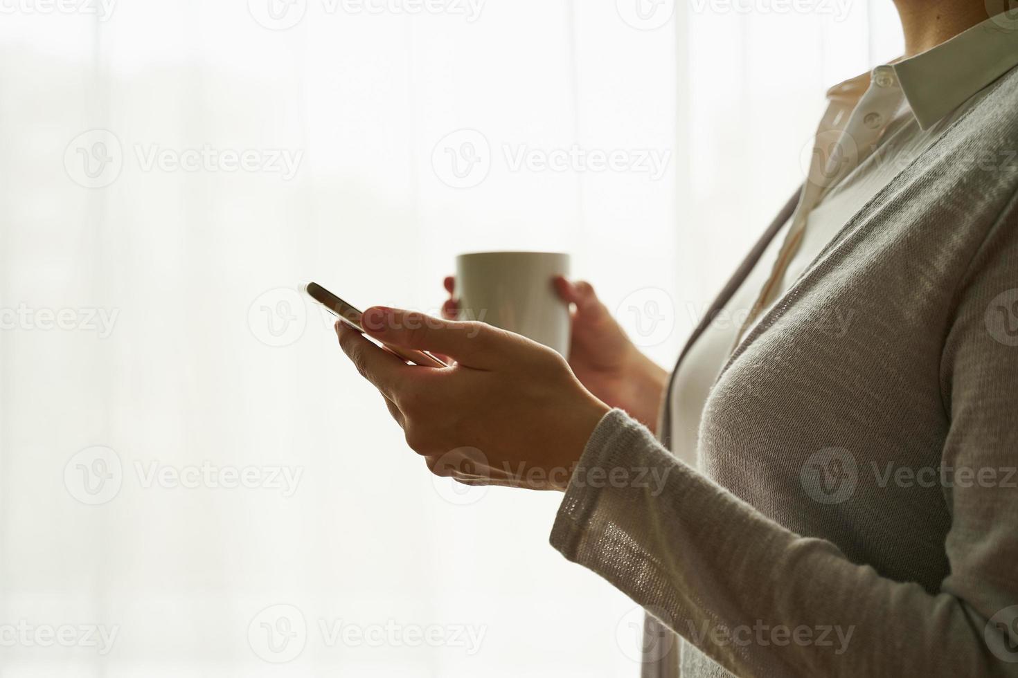 Unrecognizable female person holding a cup of tea coffee, copy space side view closeup photo