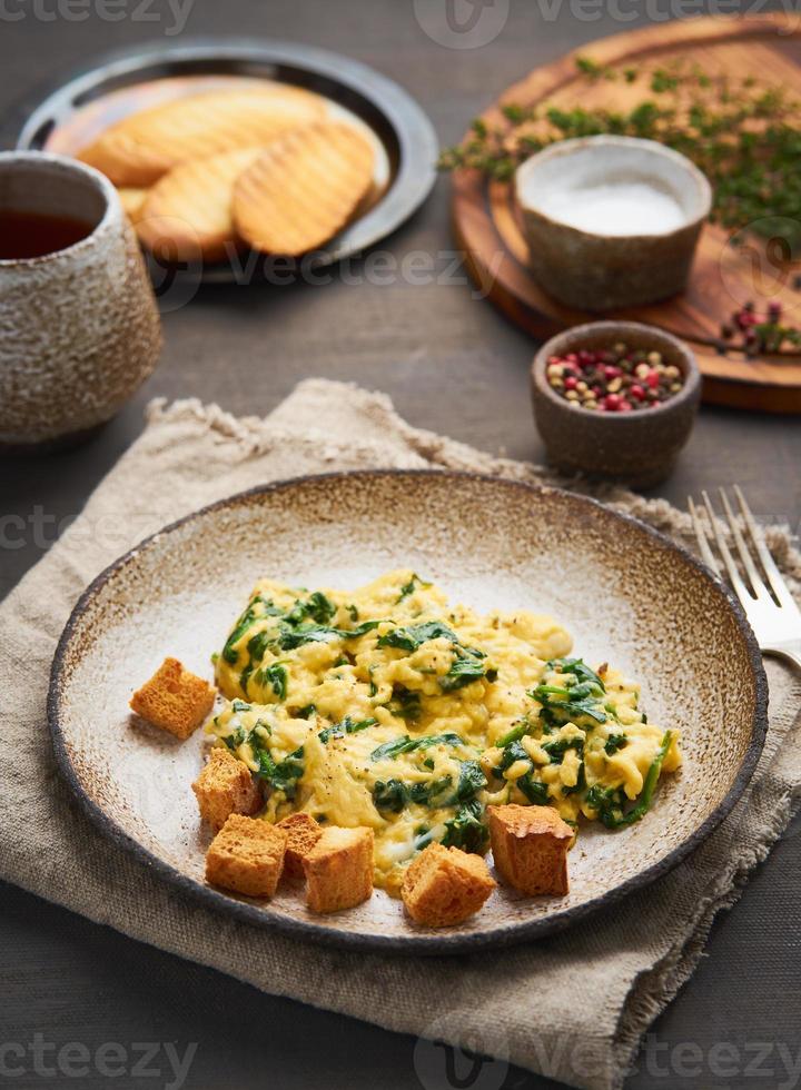 Scrambled eggs with spinach, cup of tea photo