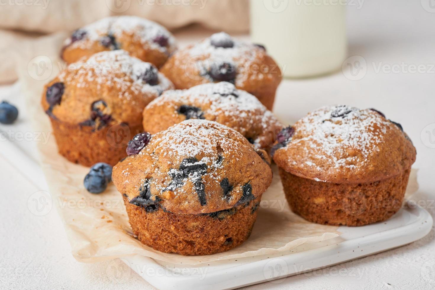 Blueberry muffin, side view, close up. Cupcakes with berries on white concrete table photo