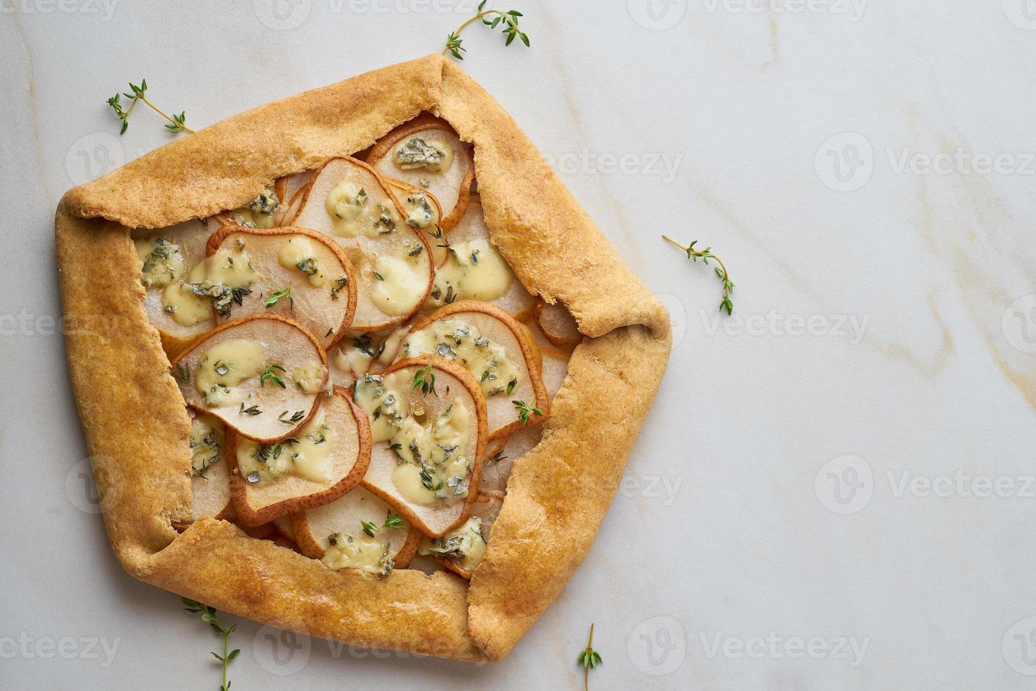 Pear galett with blue cheese, savory pie, marble table, copy space, top view photo
