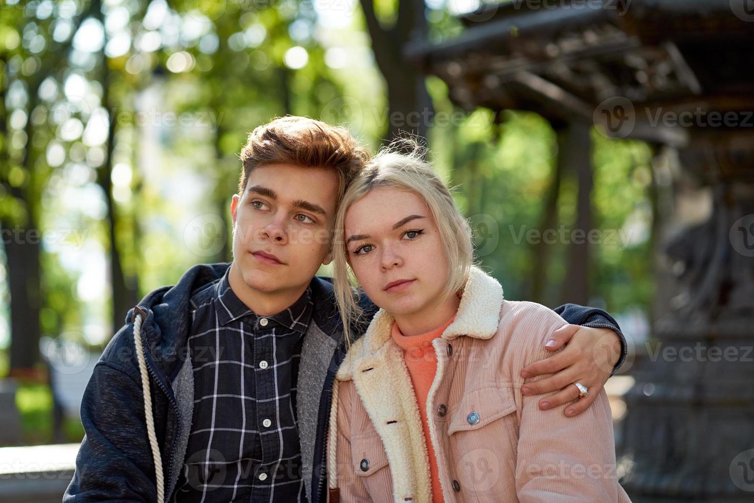 Girlfriend and Boyfriend falling in love, sitting and dreaming in Park near fountain in fall. Concept of love and happiness photo