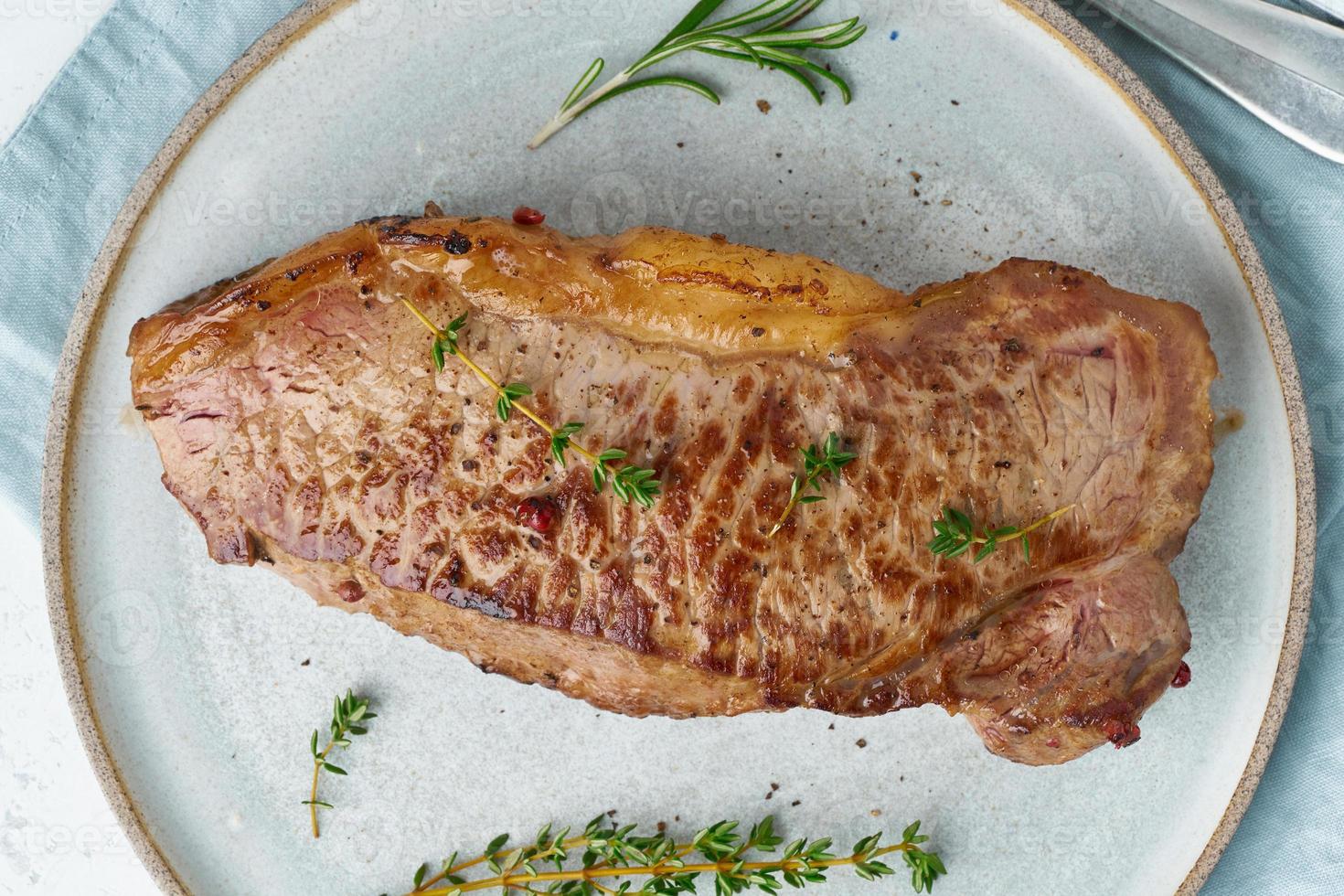 bistec de ternera de dieta cetocetogénica, lomo en placa gris sobre fondo blanco. comida paleolítica foto