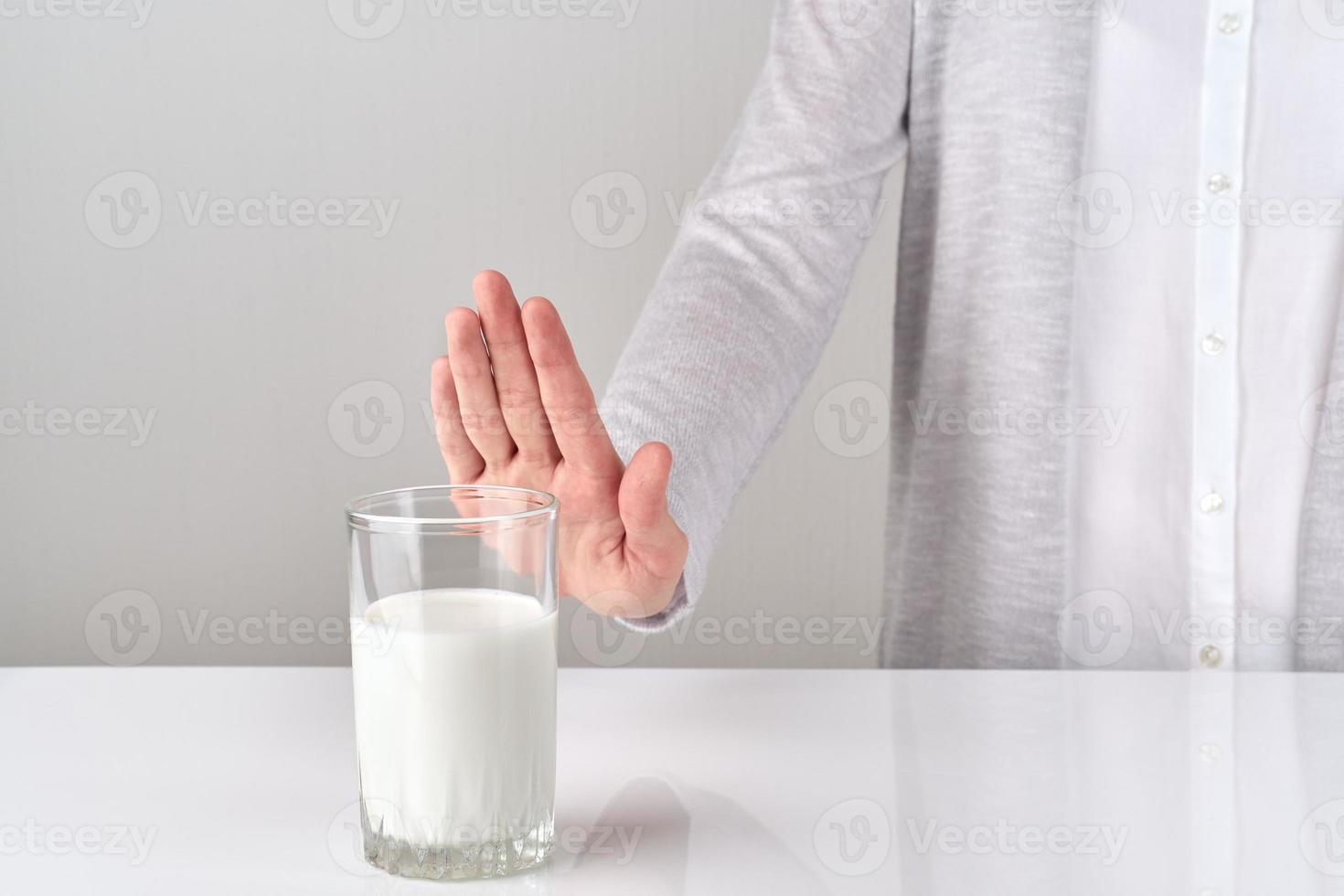 woman with lactose intolerance refusing glass of milk photo