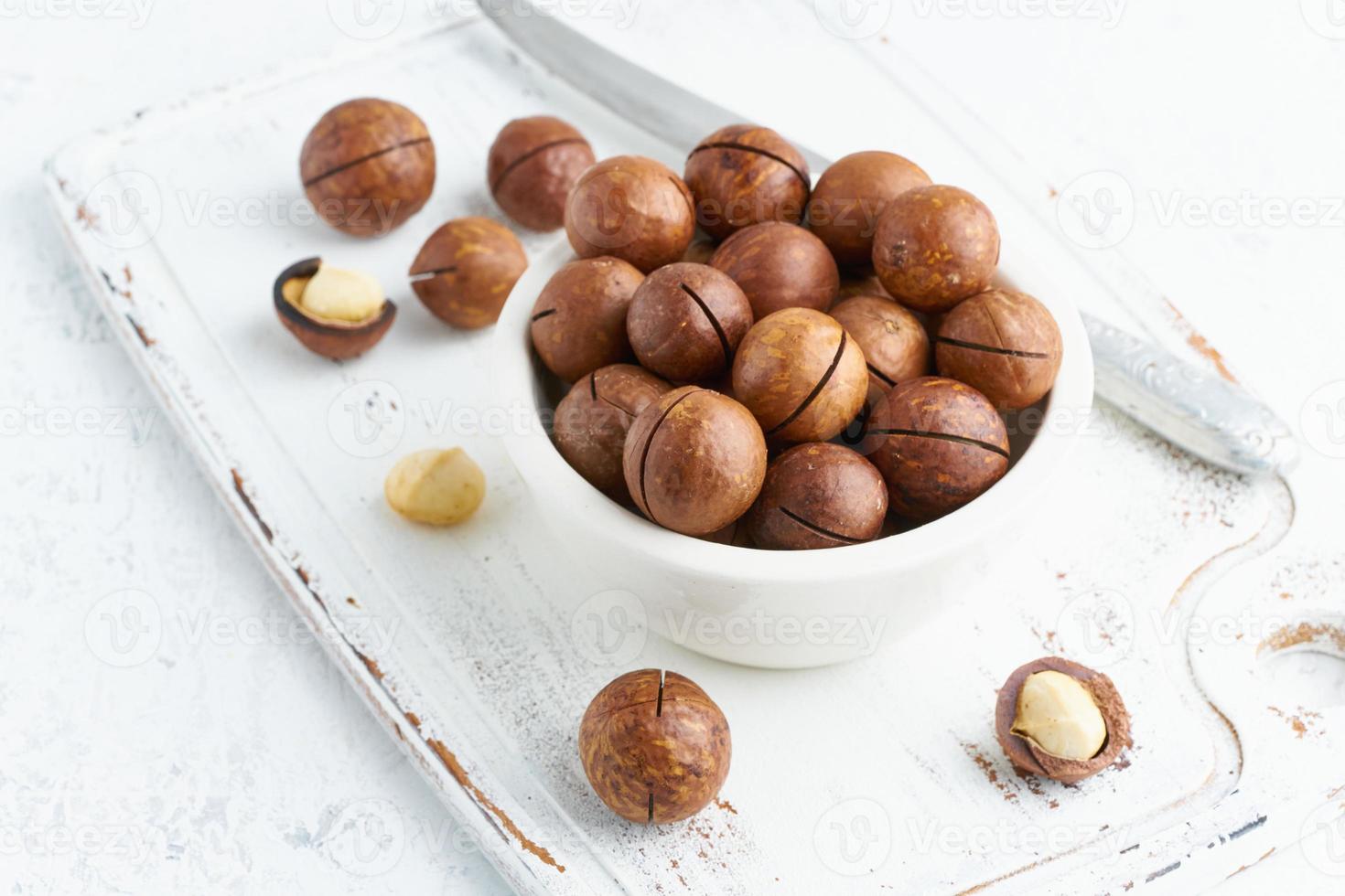 Plate with almonds in endocarp, whole and chopped open nuts in bulk photo