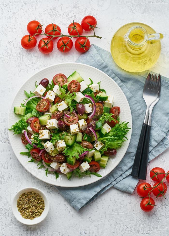 Greek Salad with feta and tomatoes, dieting food on white background vertical top view photo