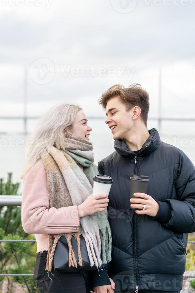 Teenage love concept. Cute brunette guy young blonde girl photo