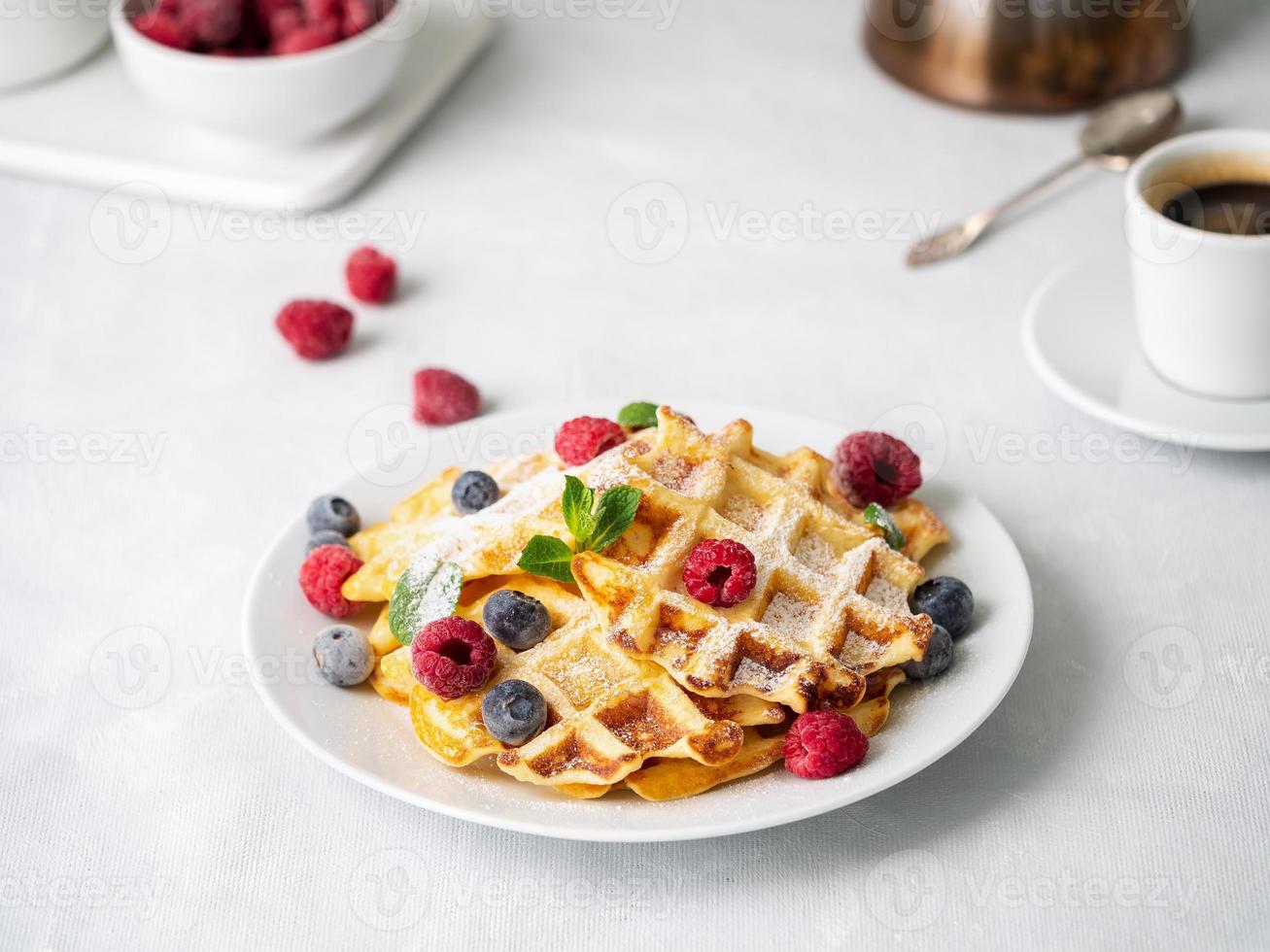 Belgian waffles with raspberries, blueberries, curd and coffee photo