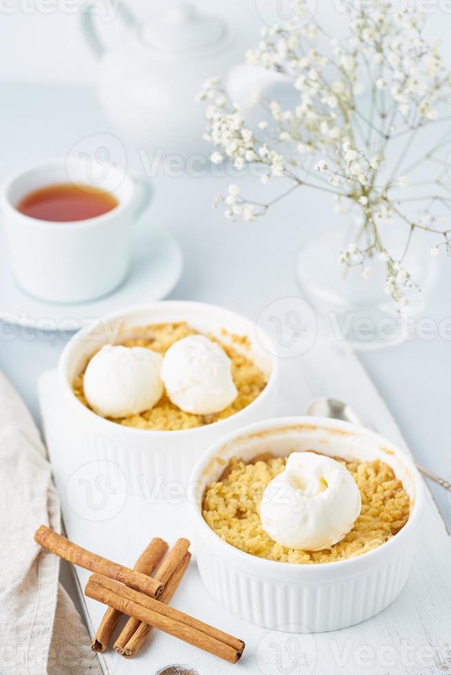 crumble de manzana con streusel, té, canela sobre una mesa gris claro. vertical. foto