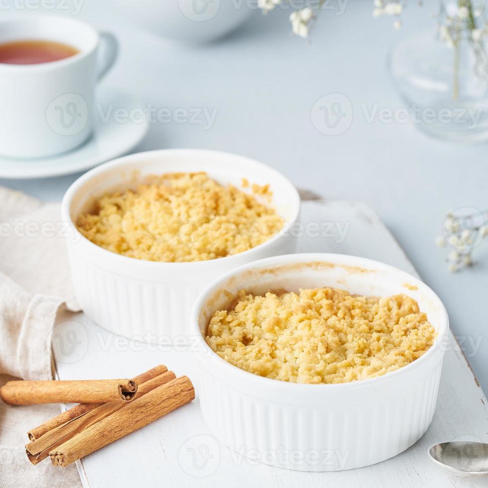 cierre el crumble de manzana con streusel. vista lateral, primer plano. desayuno matutino en una mesa gris claro. foto