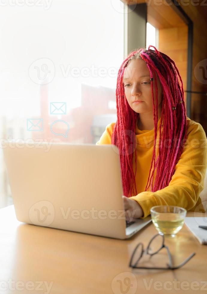 Digital nomad concept. Girl freelancer remotely working on laptop in cafe, coworking. photo