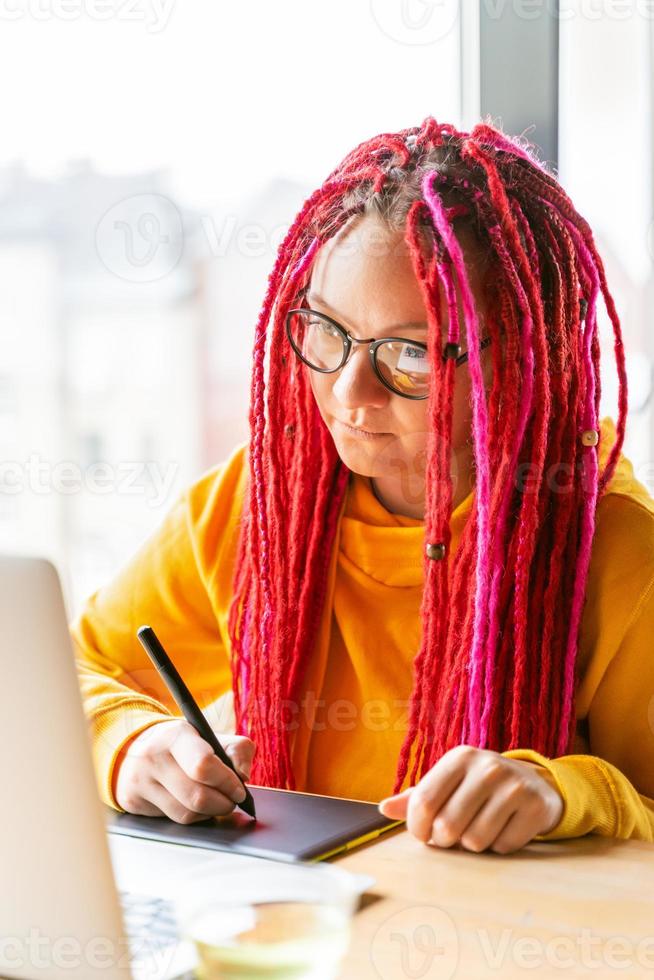 concepto de nómada digital. chica independiente que trabaja de forma remota en una computadora portátil en un café, coworking. foto