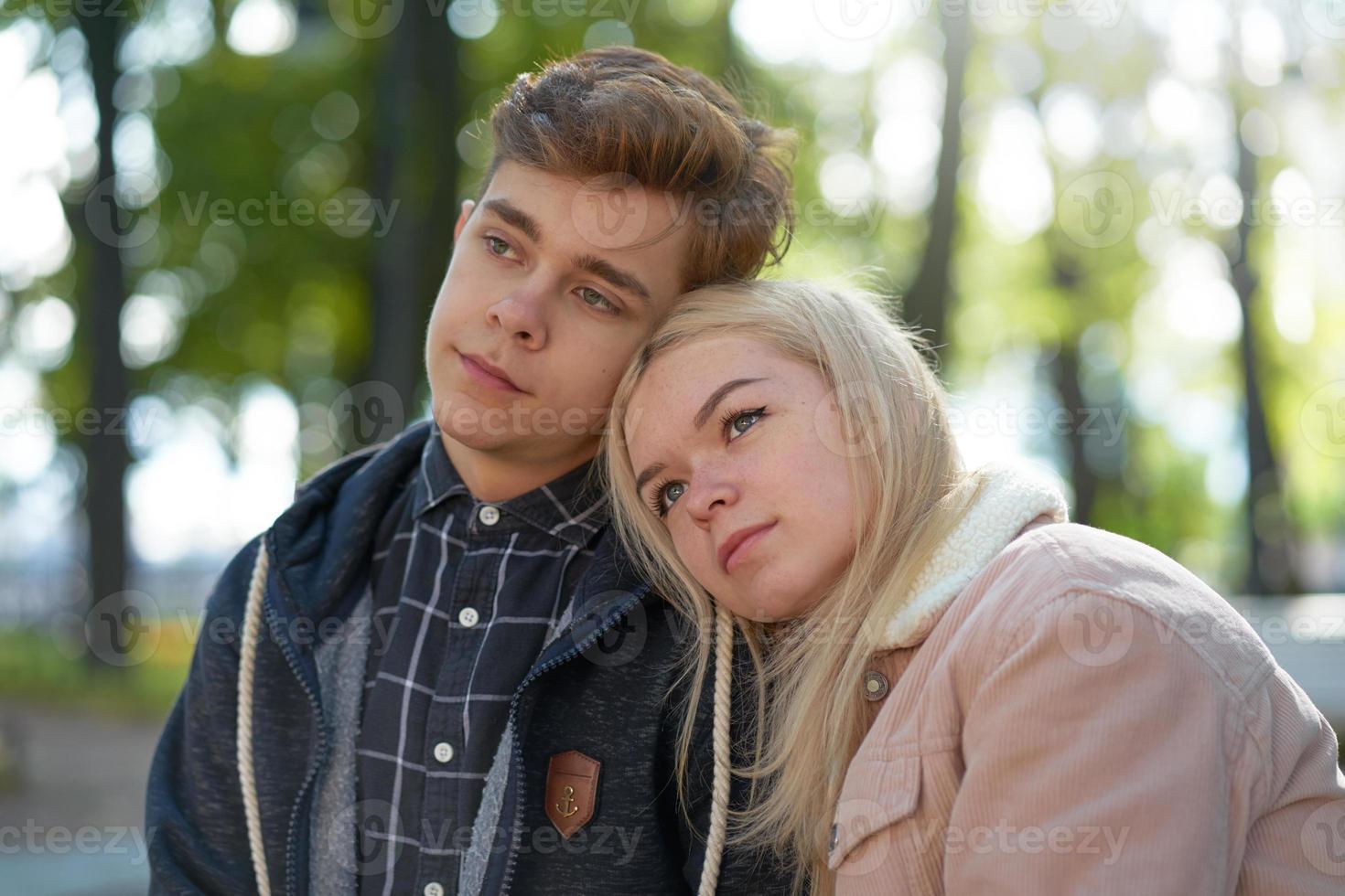 Teenagers in love dreaming in the rays of autumn sun. Concept of teen love and happiness photo