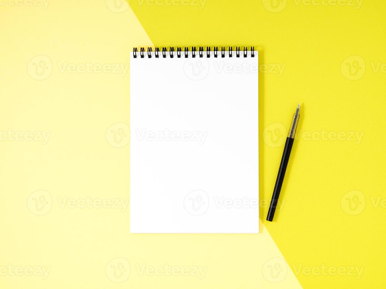 Blank notepad white page on yellow desk, color background. Top view, empty space for text. photo