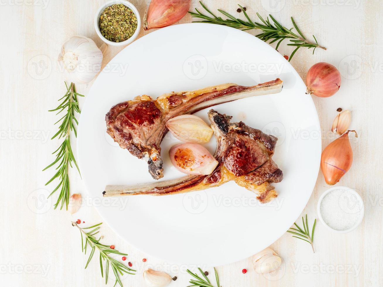 costillas de cordero fritas con grasa, paleo, dieta lchf en plato blanco con vegetales foto