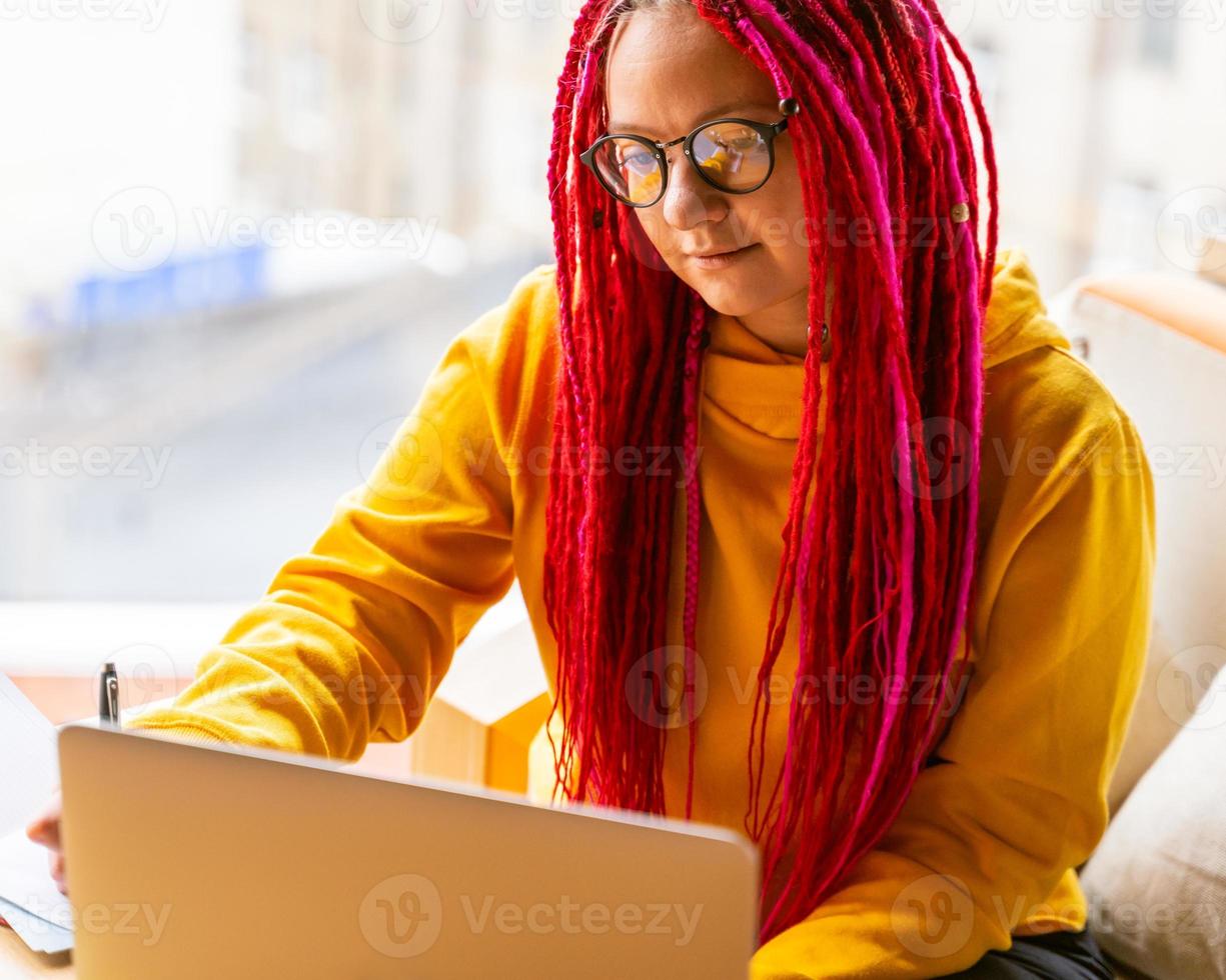 Digital nomad concept. Girl freelancer remotely working on laptop in cafe, coworking. photo