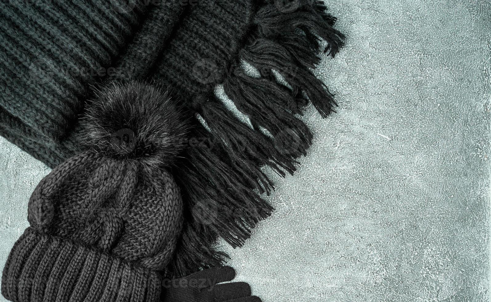 Flat lay winter or autumn warm woman accessories - black knitted scarf, hat, photo