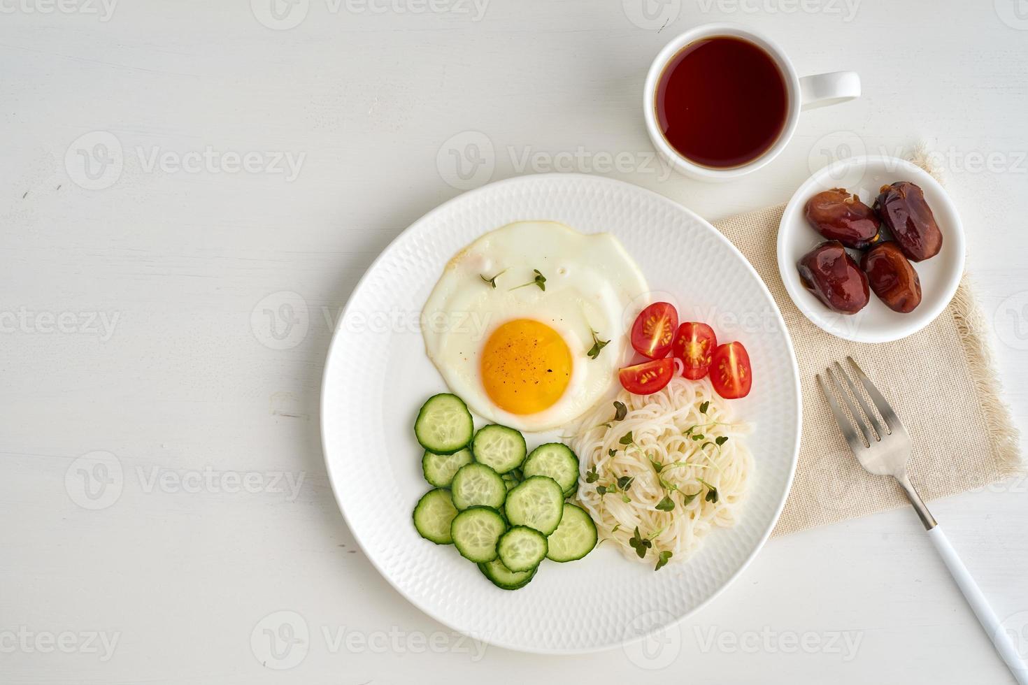 Healthy breakfast - fried egg with cherry tomatoes and cucumber photo