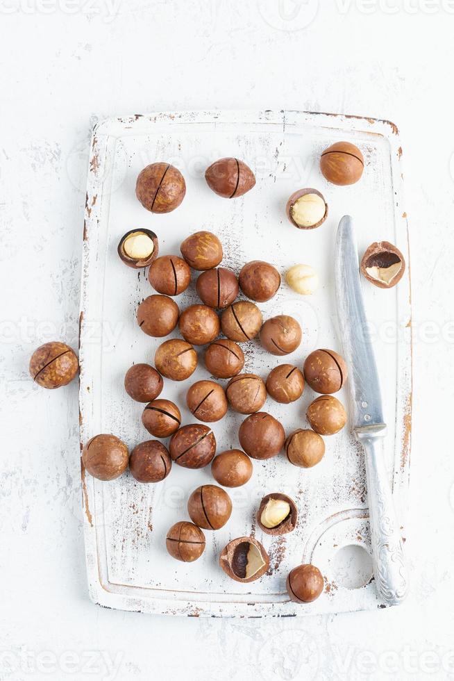 Plate with almonds in endocarp, whole and chopped open nuts in bulk on a cutting board photo