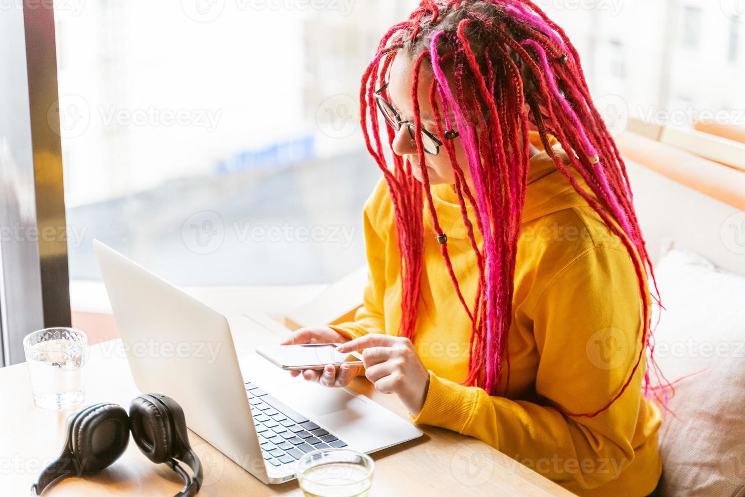 concepto de nómada digital. chica independiente que trabaja de forma remota en una computadora portátil en un café, coworking. foto