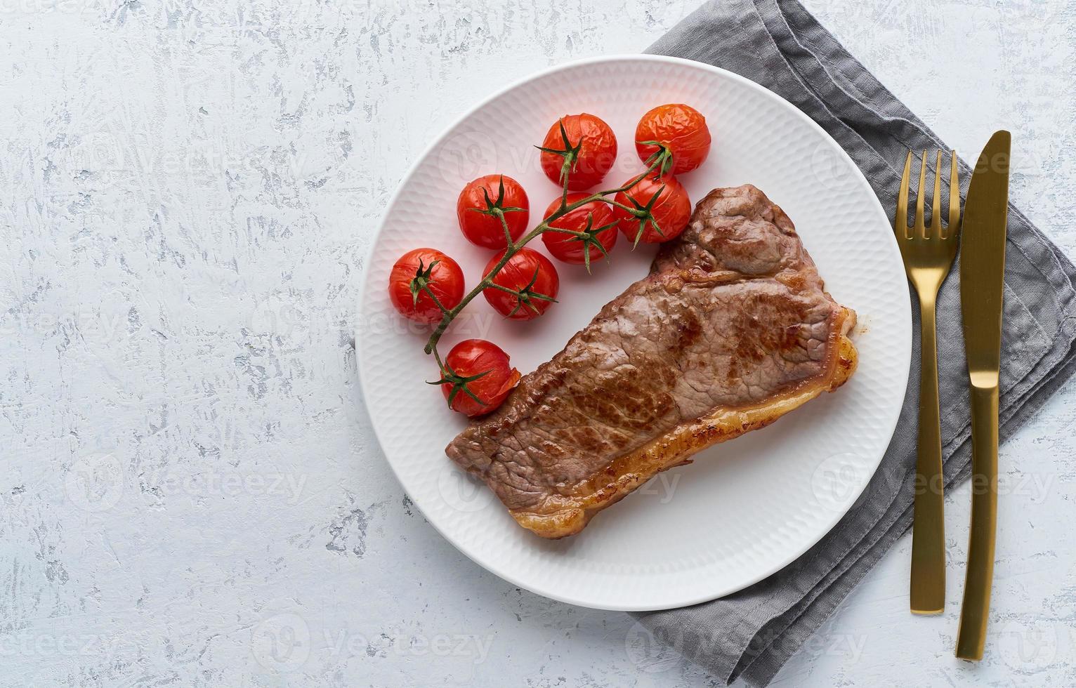 filete de dieta cetocetogénica con tomates sobre fondo blanco, vista superior foto