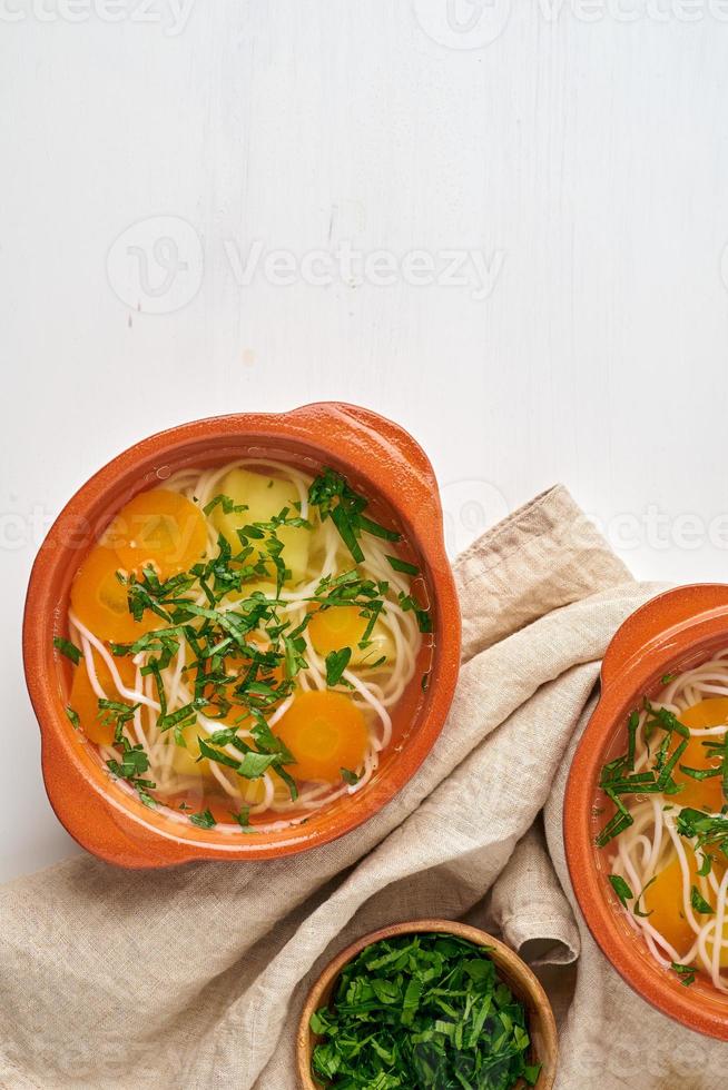 Healthy chicken soup with vegetables and rice noodles, fodmap dash diet, top view copy space photo