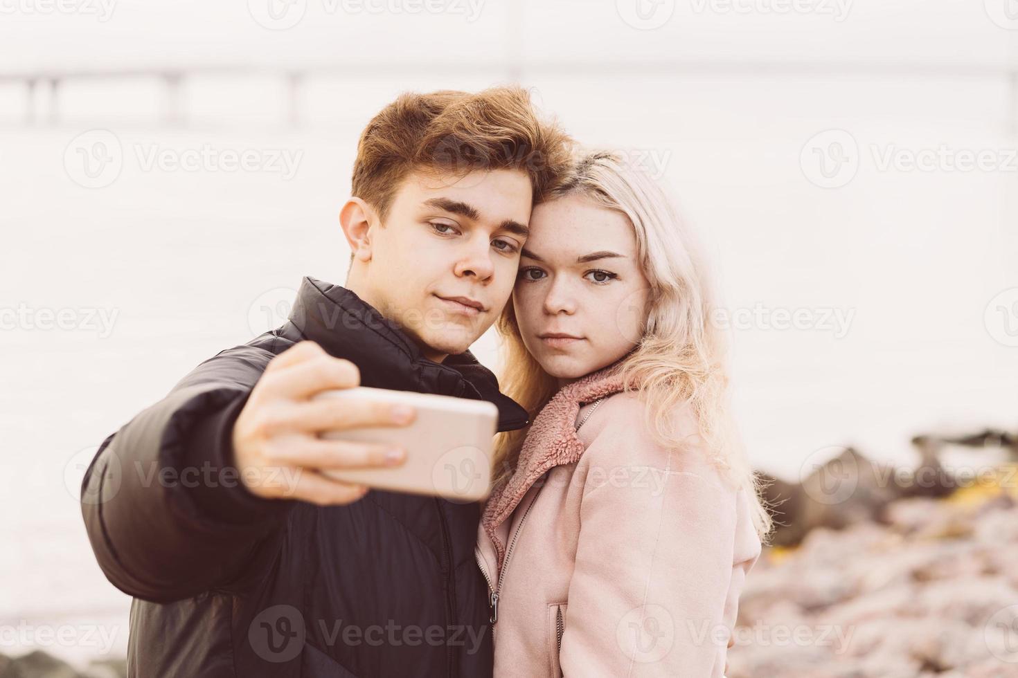 Teenage love concept. Cute brunette guy young blonde girl photo