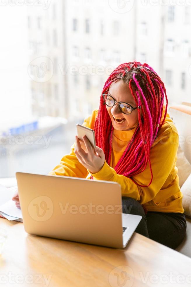 concepto de nómada digital. chica independiente que trabaja de forma remota en una computadora portátil en un café, coworking. foto