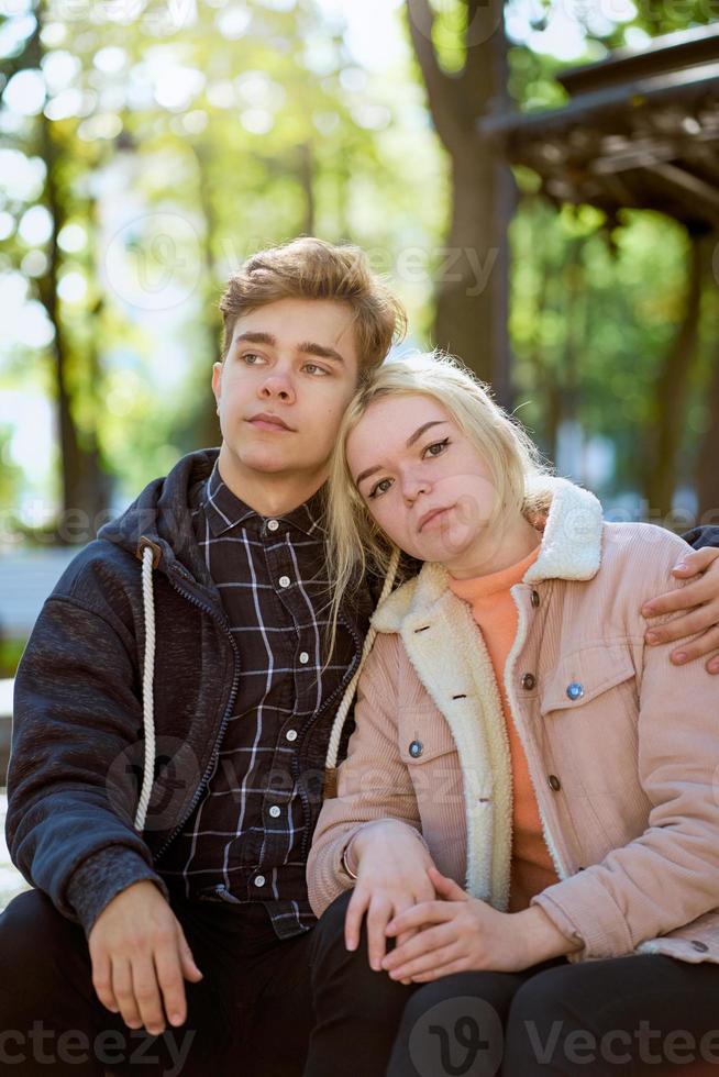 novia y novio enamorándose, sentados y soñando en el parque cerca de la fuente en otoño. concepto de amor y felicidad foto