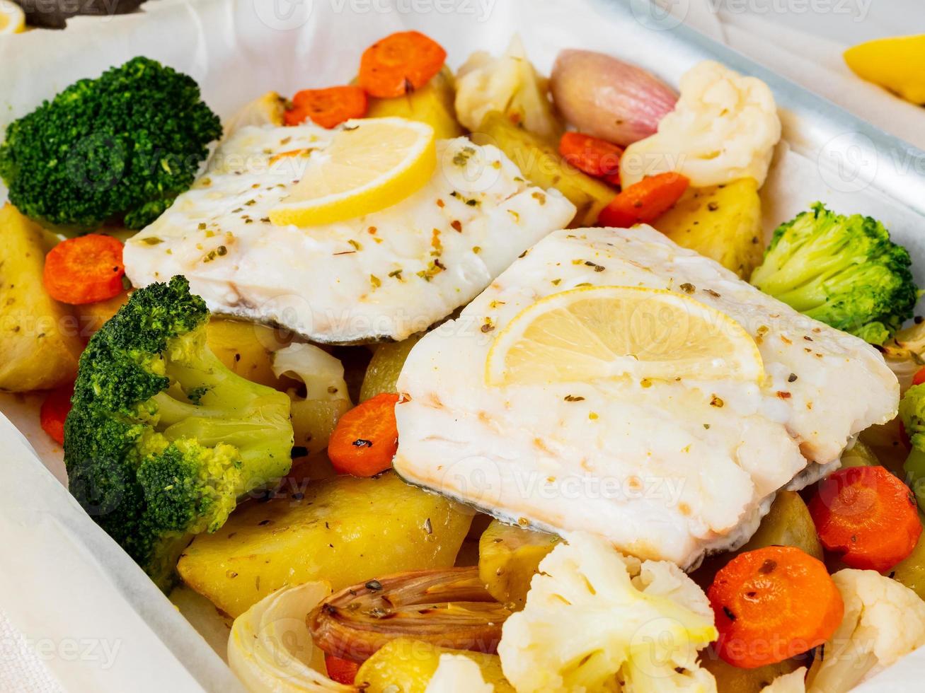 bacalao al horno con verduras - dieta sana comida sana. mármol blanco claro foto