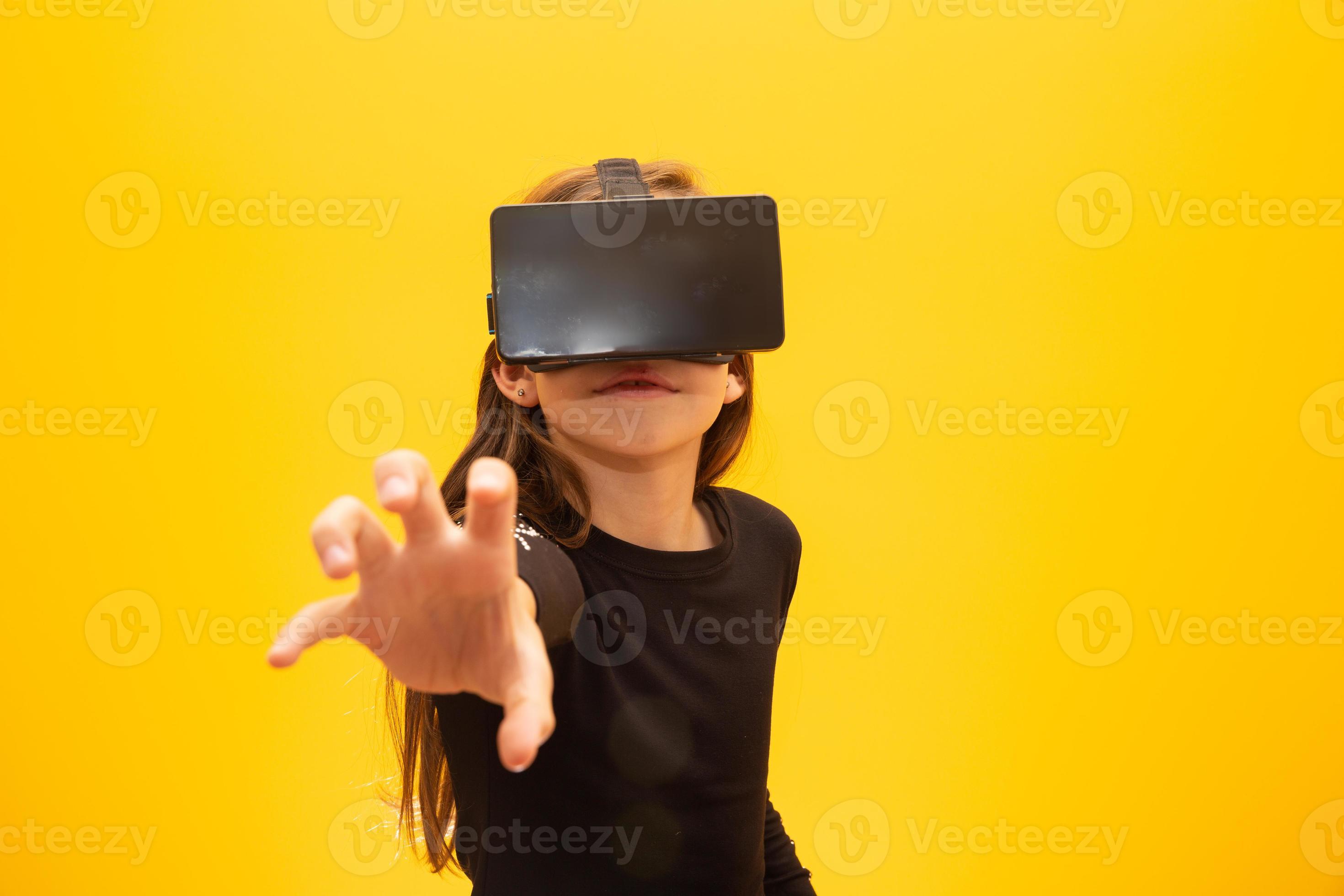Happy little girl wearing virtual reality goggles watching movies or playing video games. Cheerful smiling teenager looking in VR glasses. Funny child experiencing 3D gadget technology - close up. 7547793 Stock Photo Happy little girl wearing virtual reality goggles watching movies or playing video games. Cheerful smiling teenager looking in VR glasses. Funny child experiencing 3D gadget technology - close up. 7547793 Stock Photo