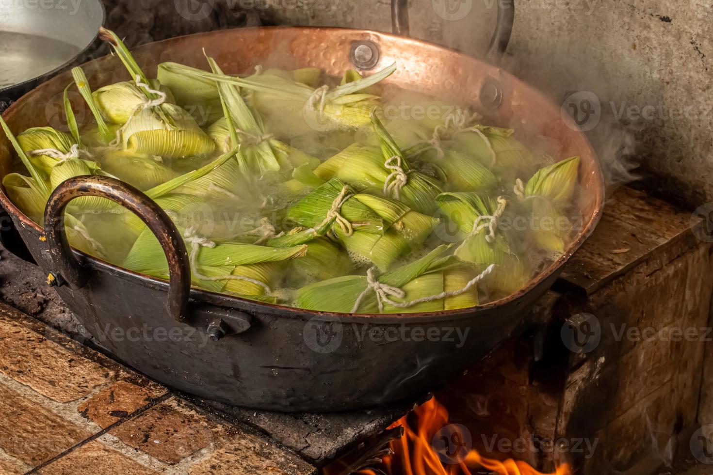 Brazilian sweet corn dessert called Pamonha. Festa Junina Party. Brazilian culture. Cooking in the pan. Wood burning stove. photo